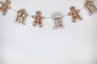 Charming gingerbread garland featuring cookies shaped as houses and gingerbread men, perfect for Christmas decor.